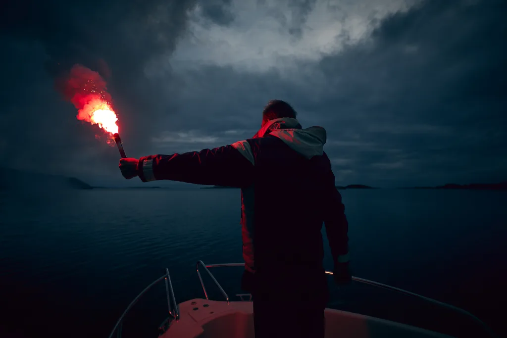 IKAROS Hand Flare Red - man holding flare in use at night