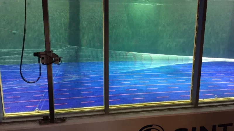 Side view of fishing nets in action during water testing in a flume tank